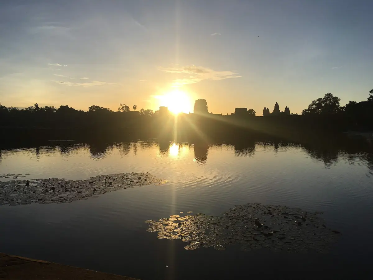 The sun rising behind the towers of Angkor Wat