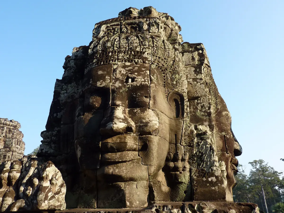 A smiling stone face on a Bayon tower