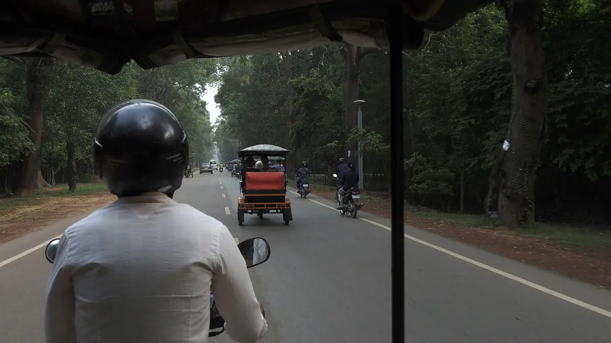 A tuk-tuk on the road to Angkor Wat
